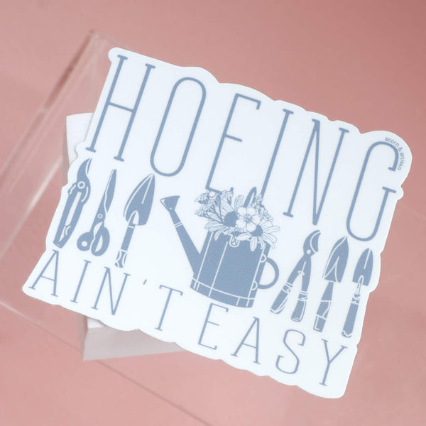 611fc05e3c4ce80992caae23_hoeing-ain-t-easy-sticker-garden-tools-and-watering-can-with-flowers_1783031989211.jpg